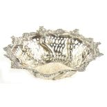 A Victorian silver dish, of shaped circular form, with a floral and scroll border, pierced sides and
