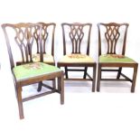 A set of four George III mahogany dining chairs, each with a pieced splat, a drop in seat and