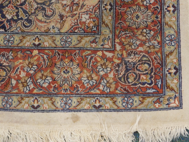 A Persian rug, with a central medallion, in orange, on a floral and leaf cream ground, with - Image 2 of 3