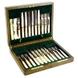 An early 20thC oak cased canteen of entree knives and forks, each with mother of pearl handles and