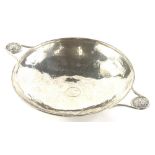 A George V silver two handled bowl, with hammered decoration, inset centrally with a Georgian silver