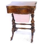 A Victorian walnut games/worktable, with the shaped top hinged to reveal chess, back gammon and