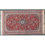 A Persian style rug, with a central pole medallion, in navy and pale blue on a red ground, with