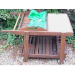 A hardwood garden trolley, with part tiled top and tray, the under tier with various divisions for