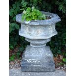 A composition gothic style octagonal garden urn on square plinth, 75cm high x 62cm wide.