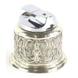 A white metal Eastern table lighter, of cylindrical form, with removable chrome insert, heavily