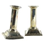 A pair of George V silver candlesticks, in neo classical style, the separate sconces with beaded