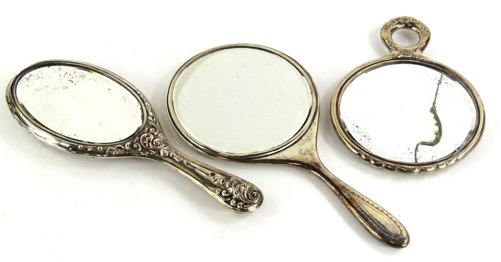 Various dressing table items, a late Victorian hand mirror, with oval glass and repousse decorated