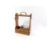 A Victorian oak and brass bound two bottle tantalus, containing a single cut glass decanter and