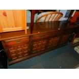 A Younger stained oak sideboard, with three drawers above four deep panelled doors, raised on a