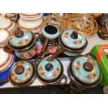 Seven floral painted saucepans and enamal cooking pots, together with a saucepan stand. (8)