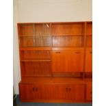 A G-Plan teak lounge unit, with an arrangement of five shelves, and a secretaire, the fall opening