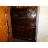 An oak kitchen dresser, with two glazed doors, open shelves above two linen fold carved doors and