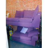 A corner sofa with curved end, upholstered in purple fabric.