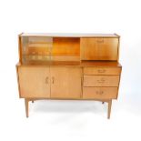 A Nathan teak sideboard, with a pair of glass sliding doors and drop down flap, above two drawers