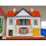 A painted wooden mid 20thC doll's house, 49cm wide.