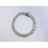 A silver and cubic zirconia tennis bracelet, on a snap clasp.