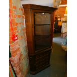 A Younger stained oak corner display cabinet, with deep moulded panel door below, raised on plinth