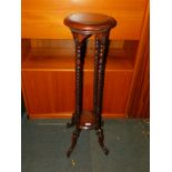 A reproduction mahogany plant stand, with barley twist supports, raised on scrolled legs, 101cm