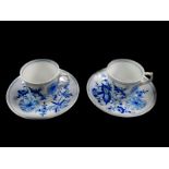 A pair of Meissen porcelain coffee cups and saucers, decorated in the Onion pattern.