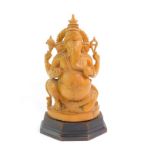 An Indian Hindu wooden carving of Ganesh, raised on a wooden stand, 25cm high.