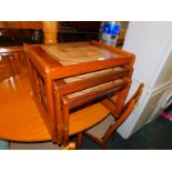 A teak nest of tables with tile tops, raised on square frame end supports, 50cm high, 59cm wide,