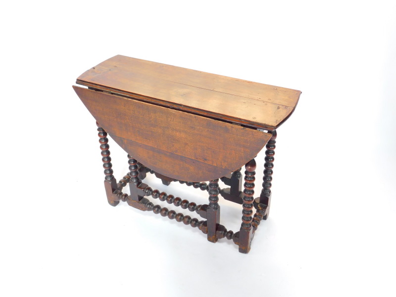 An 18thC oak bobbin turned gate leg dining table, 66cm high, 88.5cm wide, 95.5cm extended, 36cm