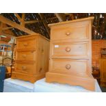 A pair of pine three drawer bedside cabinets, 64cm high, 45cm wide, 38cm deep.