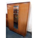 A Nathan teak double wardrobe, with a central mirrored section flanked by two doors, raised on