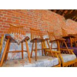 A set of four beech spindle back kitchen chairs, with birch ply seats.