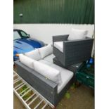 A woven plastic garden corner sofa and armchair, with loose cushions, with two matching storage