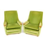 A pair of Minty teak framed armchairs, upholstered in green draylon, on castors.