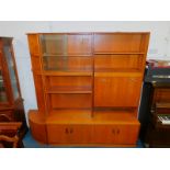 A G-Plan teak lounge unit, comprising a corner section with two shelves above a pair of cupboard