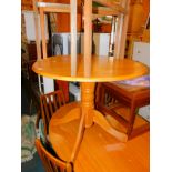 A hardwood drop leaf pedestal kitchen table, 75cm high, 92cm diameter.