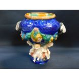 A majolica jardiniere, with ram's heads handles moulded with fruit swags and portraits, raised on