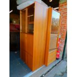 A teak effect three section wall unit, enclosing glazed display cabinets, cupboard and drop down