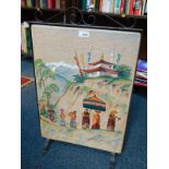 A cast iron fire screen, with a fabric panel painted and embroidered with the Dali Lama and