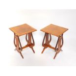 A pair of reproduction mahogany occasional tables, with cross banded tops, harp end supports, raised