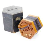 An early to mid 20thC concertina squeeze box, of hexagonal form with ten buttons to either side,