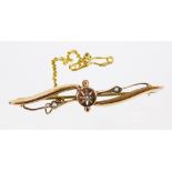 An Edwardian brooch, of entwined form set with small pearls, with star centre and plain pin back,