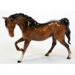 A 20thC Beswick horse, front right leg raised, printed marks beneath, 19cm high.