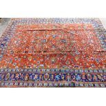 A 20thC Persian carpet, the outer field decorated with a repeat floral pattern predominately in