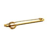 A horseshoe type pin, with plain stick surmounted by a horseshoe, with plain pin back, marked 9ct,