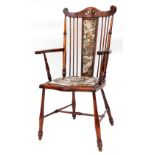 An Edwardian mahogany stained spindle back armchair, with pierced dome top, overstuffed back and
