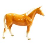 A 20thC Beswick figure of a standing Palomino horse, printed marks beneath, 20cm high.