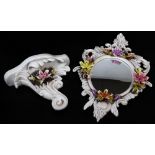 A 1970's Capodimonte mirror, of oval form, elaborately decorated and raised with flowers with a