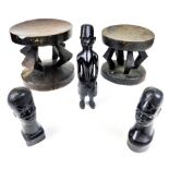 Various tribal items, two shaped stools, head figures and a statue of a tribal figure semi clad,