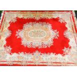 A large Chinese rug, decorated with flowers, predominantly in red, cream and green, with certificate