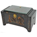 A 20thC Chinese lacquer camphor wood chest, of shaped rectangular form, the glass top revealing a