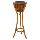 An early 20thC mahogany plant stand, with removable metal liner of circular form, on triple inverted